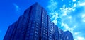 Part of a modern residential complex, an apartment building with a flat building facade against the blue sky. Royalty Free Stock Photo