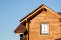 Part of modern wooden country house with blue sky on background. Roof of eco residential building near forest. Building and archit Royalty Free Stock Photo