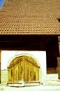 part of an old barn with a new tiled roof and old wooden gate