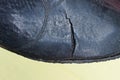 part of an old black rubber boot with a torn hole and cracks Royalty Free Stock Photo