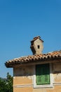 Part of an old Croatian house with a chimney on the roof against the blue sky on a sunny day Royalty Free Stock Photo