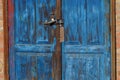 Part of the door of blue frayed wooden planks and padlock Royalty Free Stock Photo