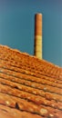 Red roof tiles with red chimney against blue sky Royalty Free Stock Photo