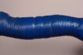 Part of an old instrument from a curved handle wrapped in blue electrical tape