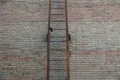 Part of an old iron fire ladder in rust on a brown brick wall Royalty Free Stock Photo