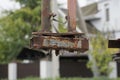 Part of old metal structure with gray iron pipes plate and bolts in brown rust