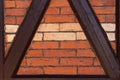 Part of an old wall made of brown half-timbered, bricked with bricks in different shades