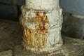 Part of an old white iron pipe with brown rusty water leaking Royalty Free Stock Photo