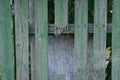 Part of an old wooden gray green fence wall with a broken plank Royalty Free Stock Photo