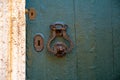 Part of an old wooden door with an iron handle and keyholes