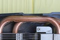 part on a one black disassembled video card with a gray metal radiator and copper brown cooling pipes