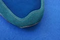 Part of one sneaker made of green suede and blue fabric Royalty Free Stock Photo