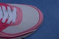 Part of one sports sneaker made of white fabric and red leather Royalty Free Stock Photo