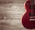 Part of the orange electric guitar on wooden background. A place for writing of the text.