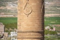 Part of an ornate minaret with raised patterns and letters