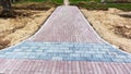 Part of the pavement of the construction site with repair work and red and gray fragments of paving stones in plan view