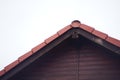 Part of the pediment of a wooden house with a red rooftop metal tile