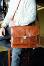 Part photo of a man with a orange leather briefcase with antique and retro look. indoors photo Royalty Free Stock Photo