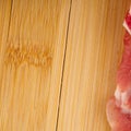 Part of a piece of red meat on a wooden chopping board closeup. Lots of space for text