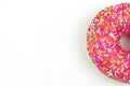Part of Pink donut decorated with colorful sprinkles isolated on white background. Flat lay. Top view Royalty Free Stock Photo