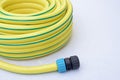 Plastic yellow rolled up hose pipe with connector on white background Royalty Free Stock Photo