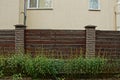 A piece of brown wooden fence in green grass Royalty Free Stock Photo