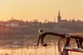 Part of a racing bike on the river in the evening light in front of the skyline, insects fly through the light Royalty Free Stock Photo