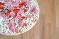 Part of raw pizza on brown kitchen table top view closeup