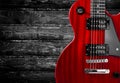 Part of the red electric guitar on wooden background. A place for writing of the text. Royalty Free Stock Photo