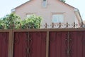 Part of a red metal fence with sharp brown rods