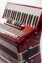 Part red musical instrument accordion, white background