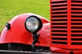 frontal part of a red vintage car with blurred greenery background Royalty Free Stock Photo