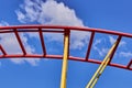 Part of a roller coaster. Background of blue sky and white clouds. Royalty Free Stock Photo