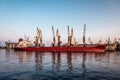 Part of the sea cargo port with different harbor cranes, dry cargo ship