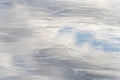 Part of a shiny, frozen lake, with reflection of the blue cloudy sky. Background, backdrop Royalty Free Stock Photo
