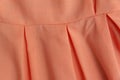 Part of skirt or dress is pale pink shade close-up. Womens clothing in fold of bright color as background Royalty Free Stock Photo