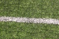 Part of sport soccer stadium and artificial turf football field. Detail, close up of green grass with white lines, goal line. Royalty Free Stock Photo