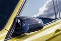 Part of a sports expensive car. carbon mirror. golden color car. the reflection of the sky Royalty Free Stock Photo