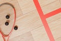 Part of a squash racket with balls on the court floor. Royalty Free Stock Photo