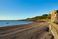 Part of St Catherine`s Bay from La Maison Slipway towards Archirondel with White Tower, the stony beach and sea wall in the Royalty Free Stock Photo