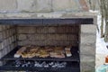 Part of stove brick masonry for barbecue with juicy steaks cooking on a grill over embers, town Zavet