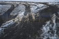 part of street in city, pavement after heavy snowfall, wet snow melts, puddles, slush and mud impede movement of pedestrians and