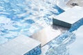 Part of swimming pool with blue mosaic ceramic tiles, with blue water, squared tiles, water surface, ripple. Background Royalty Free Stock Photo