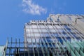 Part of a tall modern office building on the left against a cloudy sky Royalty Free Stock Photo