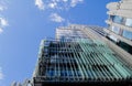 Part of a tall modern office building made of glass and concrete against a cloudy sky Royalty Free Stock Photo