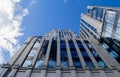 Part of a tall modern office building made of glass and concrete against a cloudy sky Royalty Free Stock Photo