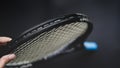 Part of tennis racket head on black background