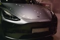 Part of Tesla car model Y in liquid silver dubbed Mercury Silver Metallic color, popular passenger electric vehicle in showroom,