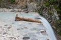 Part of tree trunk lying in beautiful stream just above the waterfall