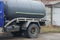 Part of a truck made of a gray iron barrel and a plastic hose for sewer cleaning